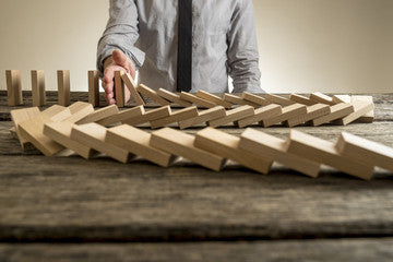 man stopping wooden blocks from falling